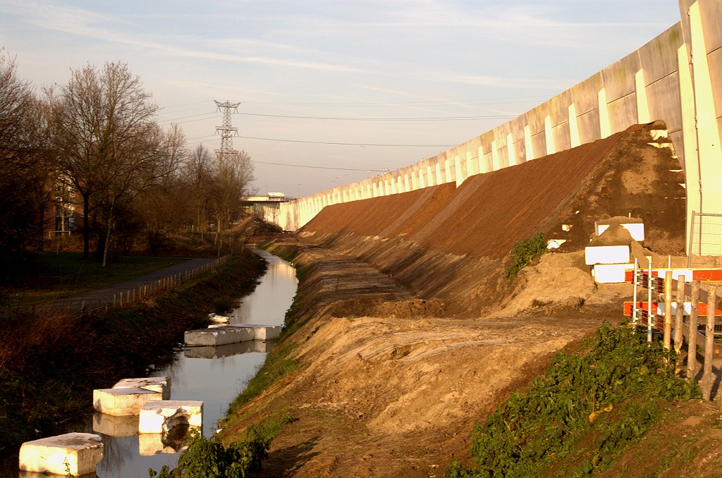 20081227-143515.bmp - Aan de achterzijde is het betonnen scherm opgeleukt met een aarden wal, die echter voor het grootste deel uit EPS (piepschuim) bestaat. Dat scheelt nogal in gewicht tegen het scherm aan.