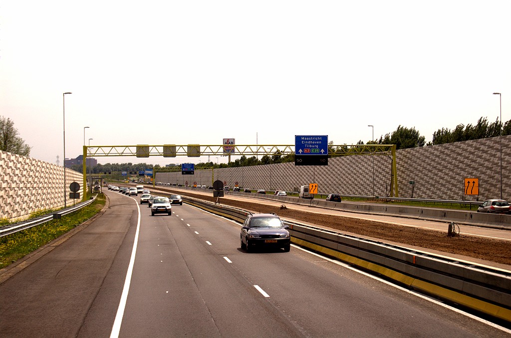 20090606-132016.bmp - 2x3 A2 verder in de richting van de Maasbrug. Zo te zien verbrede middenberm en verbreed dijklichaam. Het gehele wegvak tussen het knooppunt Empel en de Maasbrug is omsloten door hoge schermen.