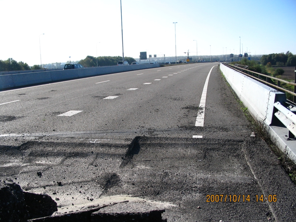 IMG_0655.JPG - Viaduct over het spoor, A2 noord, kijkende naar Kp. Batadorp. In de oude situatie was het hier TOTSO, in de toekomst is de uitvoegstrook naar de A58 west en de twee linkerstroken naar A2 Eindhoven westtangent parallelbaan. Zo te zien aan het TB en GE hoeven de viaducten over het spoor niet vervangen te worden: de drie bruggen zijn breed genoeg voor resp. 4 strooks + vluchtstrook op de zuidelijke (breedste) brug, 2 strooks + vluchtstrook op de middelste brug, en 2 strooks + uitvoegstrook op de noordelijke brug. Alleen bij een upgrade naar 3 strooks op de hoofdrijbaan over de middelste brug zou de vluchtsstrook in de knel komen.