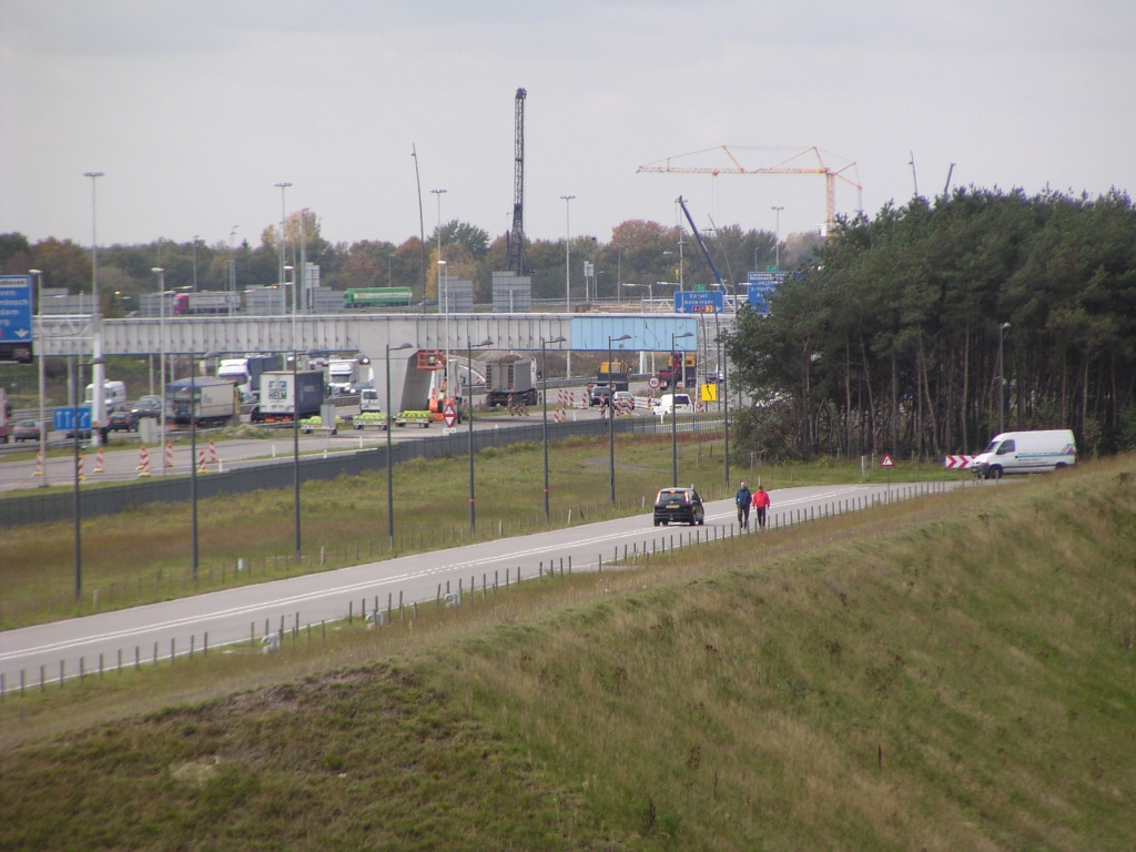 p1010007.jpg - Geluidswal High Tech Campus en twee werknemers die graag een kijkje nemen op de transformerende A67 pal aan hun werkplek.