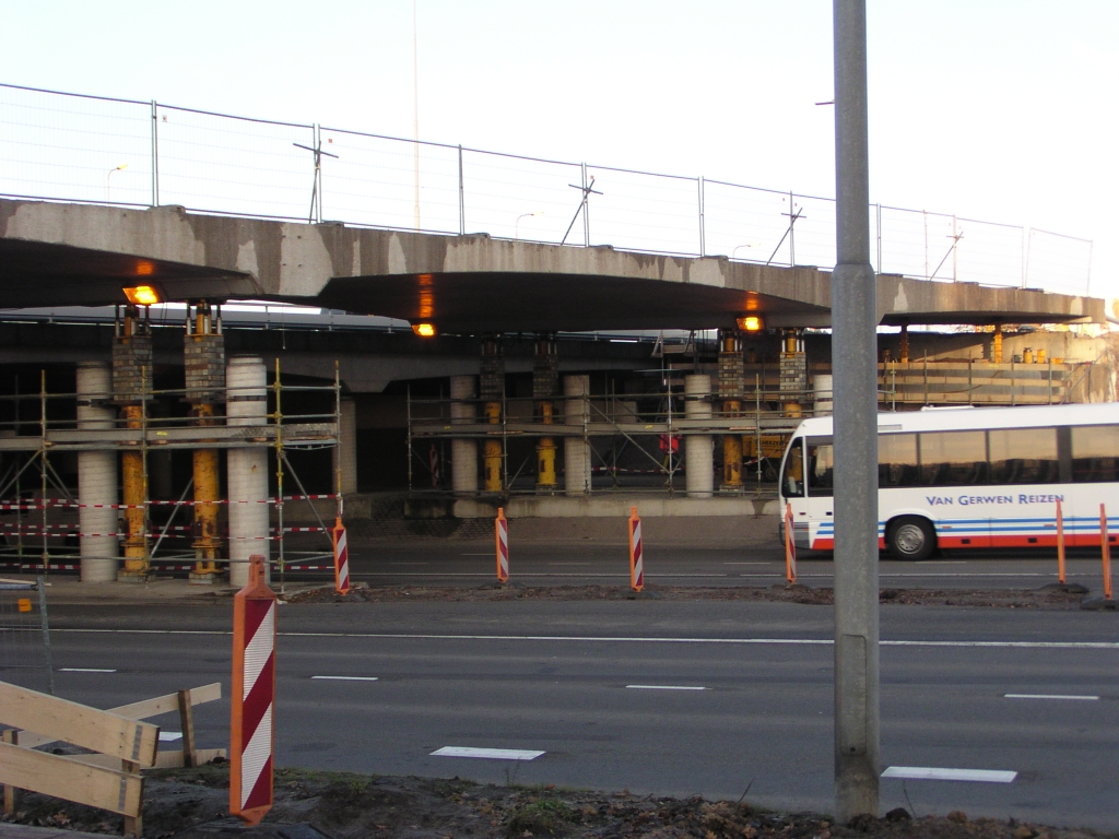 pb140001.jpg - Aansluiting Veldhoven, oostzijde. Dit viaduct droeg eerst de afrit Veldhoven vanaf de richting Maastricht, nu moet het verbreed worden omdat de parallelbaan eroverheen komt. Door die verbreding zou de doorrijhoogte onder het verkante brugdek echter te klein worden. Daarom heeft men hier met vijzels het viaduct een meter opgelicht, zodat er werkruimte ontstaat voor het verhogen van de pilaren en brughoofden met 40 cm. Zie ook het  artikel  in het Eindhovens Dagblad.