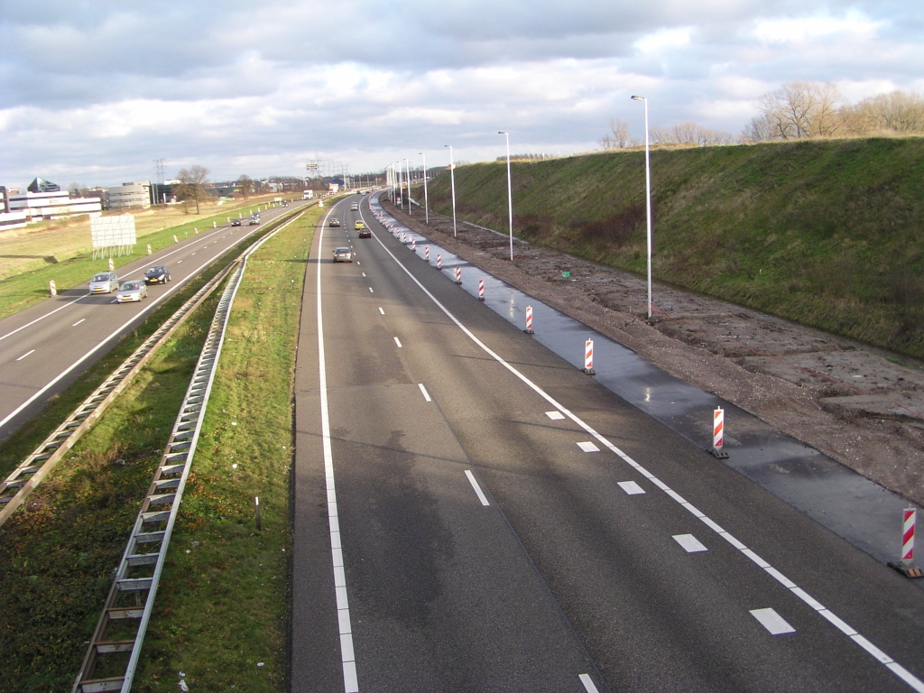 pc090017.jpg - Nieuwe uitvoeger gezien van het viaduct Huizingalaan dat zo te zien naadloos gaat aansluiten op de invoeger vanaf Kp. Ekkerswijer. Komende vanuit de richting Den Bosch hoeft men dus niet op de A58 in te voegen als men naar de Kennedylaan wil.