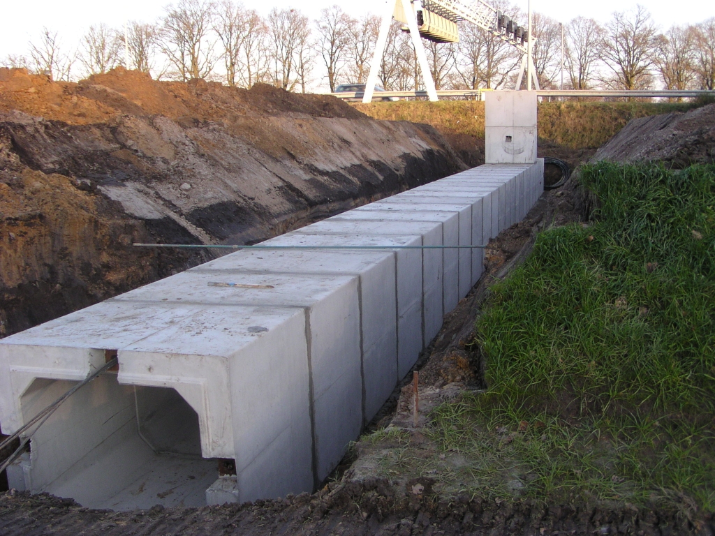 pc160022.jpg - In het wegvak parallelbaan west tussen de Oirschotse dijk en de aansluiting Airport is het pas aangelegde asfalt plaatselijk weer verwijderd en een sleuf gegraven zodat deze amfibietunnel alsnog kon worden ingepast.