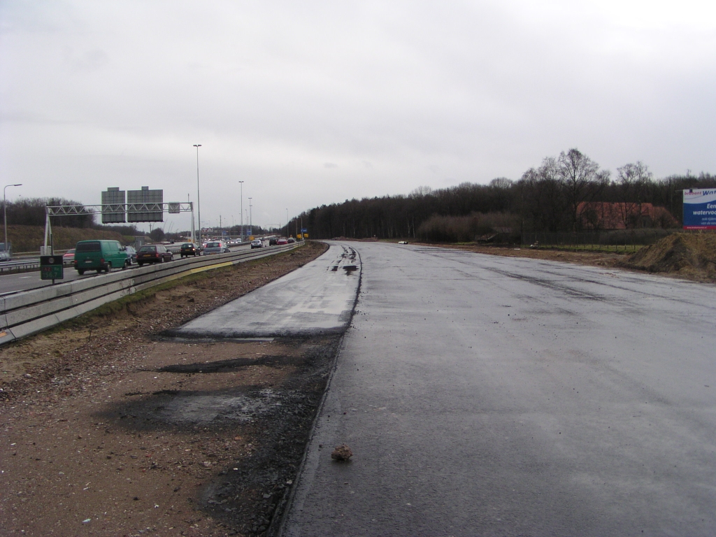 p1050003.jpg - Een stukje verder naar het zuiden zien we weer een reep aangeplakt asfalt, nu vermoedelijk voor de tijdelijke linkse uitvoeger vanaf de parallelbaan naar de afrit Strijp/Centrum.