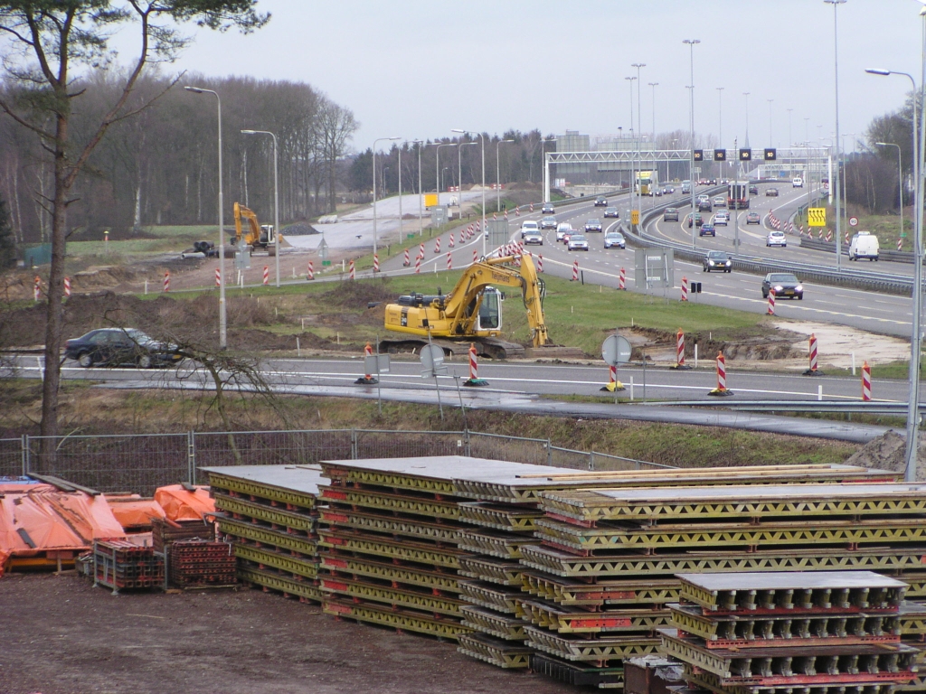 p1120004.jpg - Op de  Actuele werkzaamheden  pagina:  In het weekeinde van vrijdagavond 18 januari 20.00 uur tot maandagochtend 21 januari 05.30 uur is de afrit Eindhoven Airport (29) afgesloten voor verkeer vanuit de richting ’s-Hertogenbosch, Tilburg en Nijmegen. In dit zelfde weekeinde is ook de oprit Eindhoven Airport (29) afgesloten voor verkeer richting Maastricht, Venlo en Antwerpen.  Inderdaad is men hier bezig met grondverzet, maar 1 week lijkt wel erg kort om de parallelbaan gereed te krijgen zodat de toe- en afrit eroverheen gelegd kunnen worden. Een stukje van de nieuwe toerit vooraan is al zichtbaar: de boog wordt krapper.