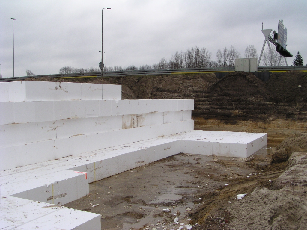 p1270005.jpg - Pal ten noorden van het viaduct Ulenpas is het zandlichaam van de bestaande hoofdrijbaan loodrecht afgegraven tot enkele meters onder maaiveldhoogte. Tot op parallelbaanbreedte is deze afgraving voortgezet, en belegd met dit bouwsel van piepschuim.