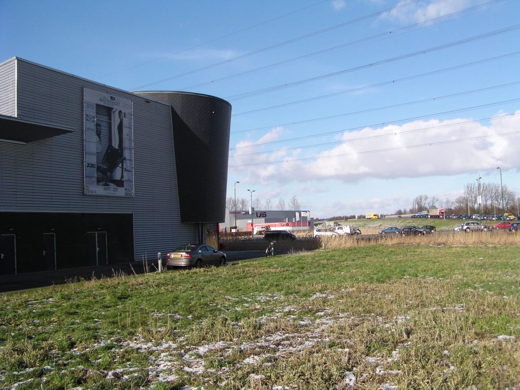 p2020002.jpg - Meubelhandel Donjon op bedrijventerrein Ekkersrijt heeft hier een mooie zichtlocatie vanaf de A50 uit de richting Nijmegen (rechtsboven). Men kan thans vanaf de A50 via een VRI geregelde kruising de meubelhandel rechtstreeks bereiken; in de toekomst verdwijnt deze mogelijkheid en zullen de klanten moeten rijden via de nieuwe aansluiting Ekkersrijt, een flink eind naar het westen. De ondernemer benut alle juridische mogelijkheden om de aansluiting op de A50 bij zijn zaak te behouden, tot aan de Raad van State toe. Laatsgenoemde heeft nu een voorlopige voorziening getroffen waardoor de wegwerkzaamheden doorgang kunnen vinden.