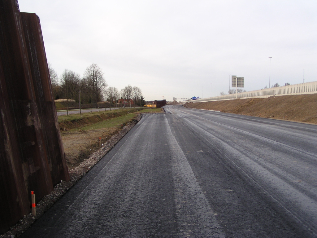 p2030023.jpg - De invoegstrook is op minimale afstand van het geluidsscherm neergelegd. Kennelijk is ook de completering van het scherm uitgesteld tot er duidelijkheid is wat er met de vermeende nieuwe aansluiting gaat gebeuren. Dat kan nog wel enige tijd gaan duren omdat er nog geen onherroepelijk trace-besluit is. Anderzijds is de afspraak dat er geen wegvakken in gebruik genomen mogen worden zonder geluidsschermen (waar die zijn voorzien). Zou dit consequenties hebben voor het voornemen om in het najaar van 2008 al het verkeer over de parallelbanen te laten rijden?