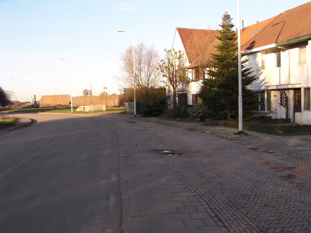 p2100040.jpg - De panden rechts staan op de tracekaart niet aangeduid als te amoveren, maar zijn goeddeels onbewoond en hebben al enkele ingegooide ruiten. De Sliffertsestraat was tot midden jaren 70 de noordelijke hoofdverbinding tussen Veldhoven en Eindhoven. Nadat de Heerbaan die functie had overgenomen is de straat aan zijn lot overgelaten.