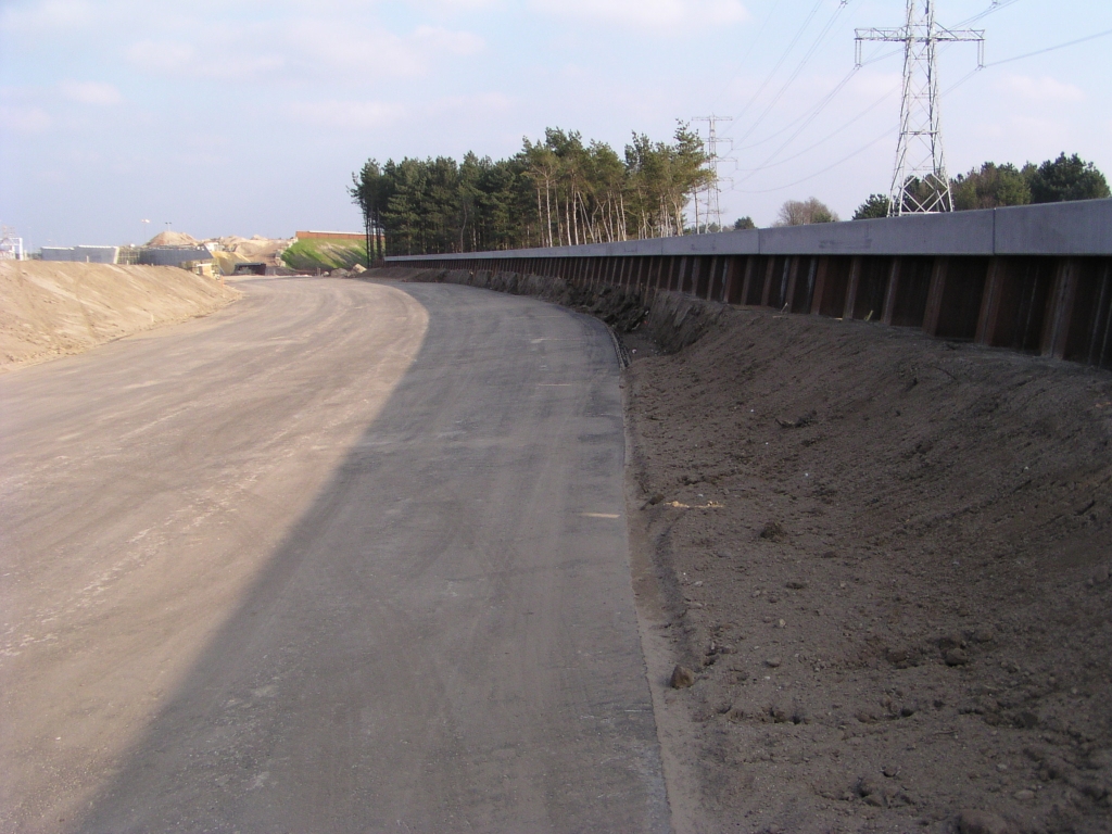 p2240008.jpg - In de buigende parallelbaan zuid richting het portaalviaduct onder de hoofdrijbaan (KW 33) is een pechhaven geasfalteerd waarvoor de kanteldijk heeft moeten wijken.