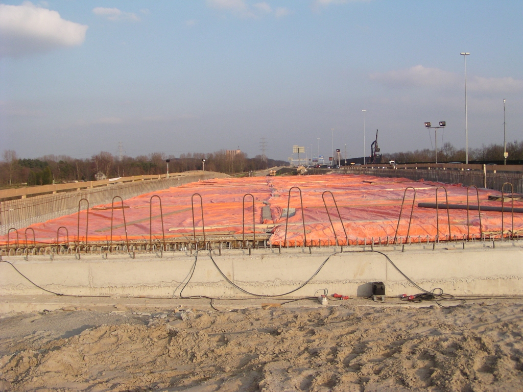 p2240016.jpg - Druklaag op KW 28 noord gestort en bedekt met zeil, om te snel uitharden met als gevolg scheuren in het beton te voorkomen (denk ik). Er is nog van allerlei uitstekend wapeningsmateriaal zodat er nog meer beton gestort gaat worden.