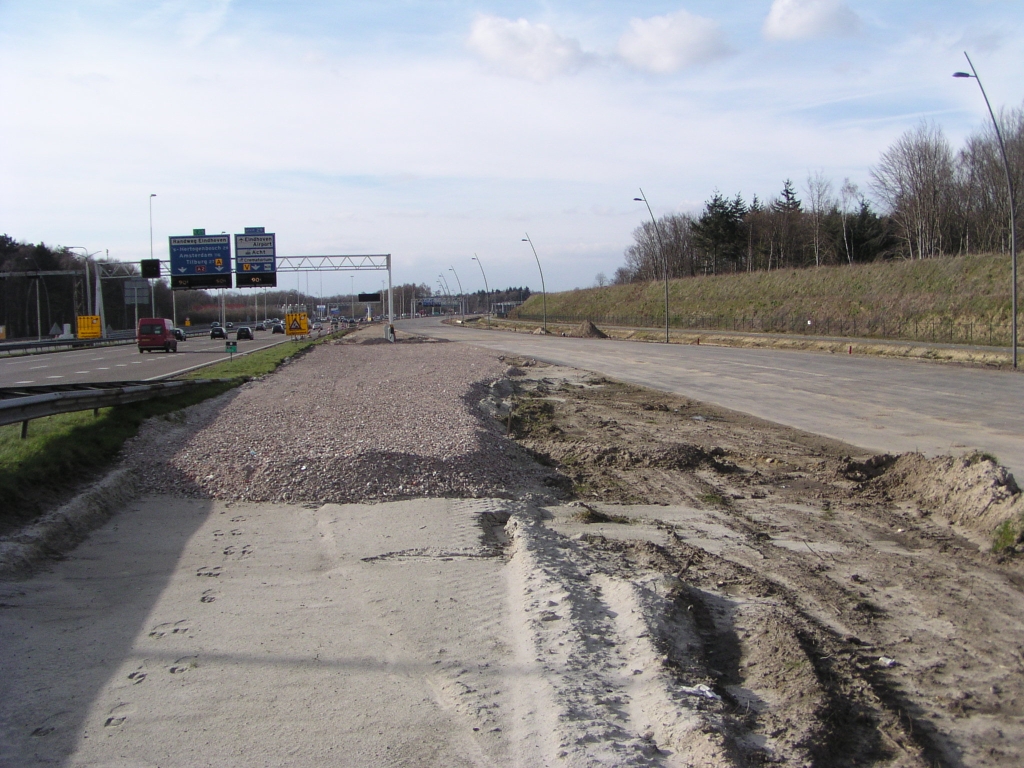 p3080027.jpg - Vanaf 6 april moet er hier, op de parallelbaan oost tussen de aansluitingen Strijp/Centrum en Airport, verkeer gaan rijden, waartoe dit doorsteekje wordt aangelegd. De rechtse staander van dat portaalbord staat nu nog middenin het doorsteektrace, maar daar zijn oplossingen voor zoals we dadelijk zullen zien.  week 200746 