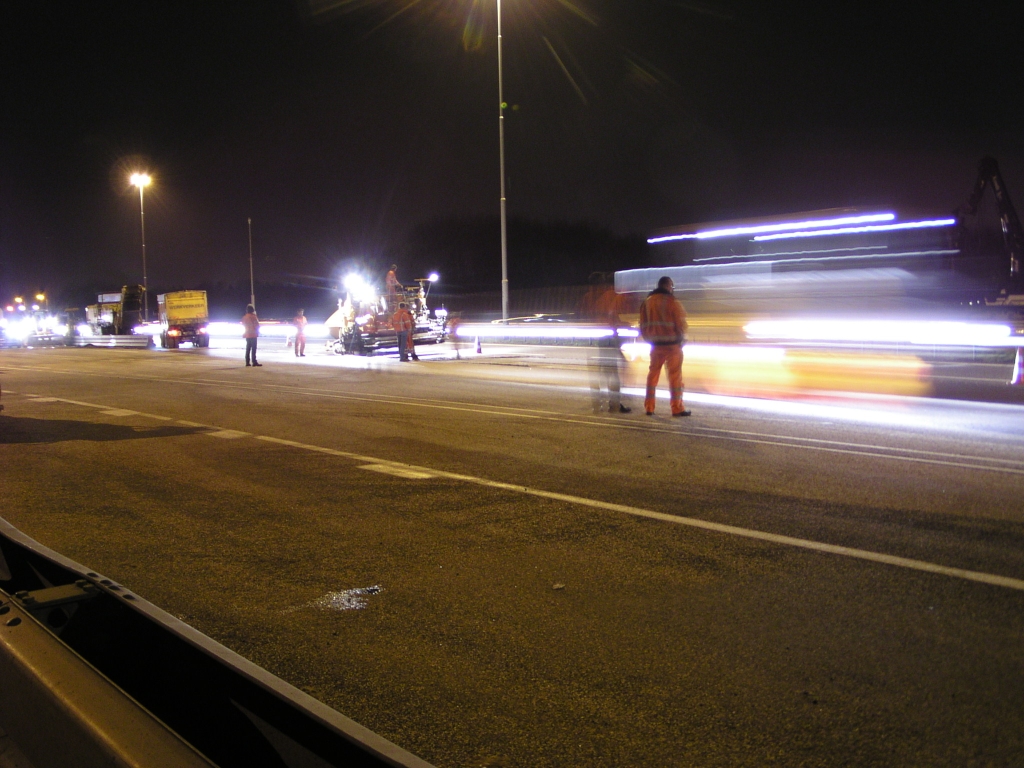 p3150012.jpg - Enkele uren voor het omzetten van het verkeer van de oude hoofdrijbaan naar de parallelbaan tussen de aansluiting Airport en de Welschapsedijk is men bij laatst genoemde plaats hard aan het werk met het voltooien van asfalteerwerkzaamheden voor de oversteek terug de oude hoofdrijbaan op.