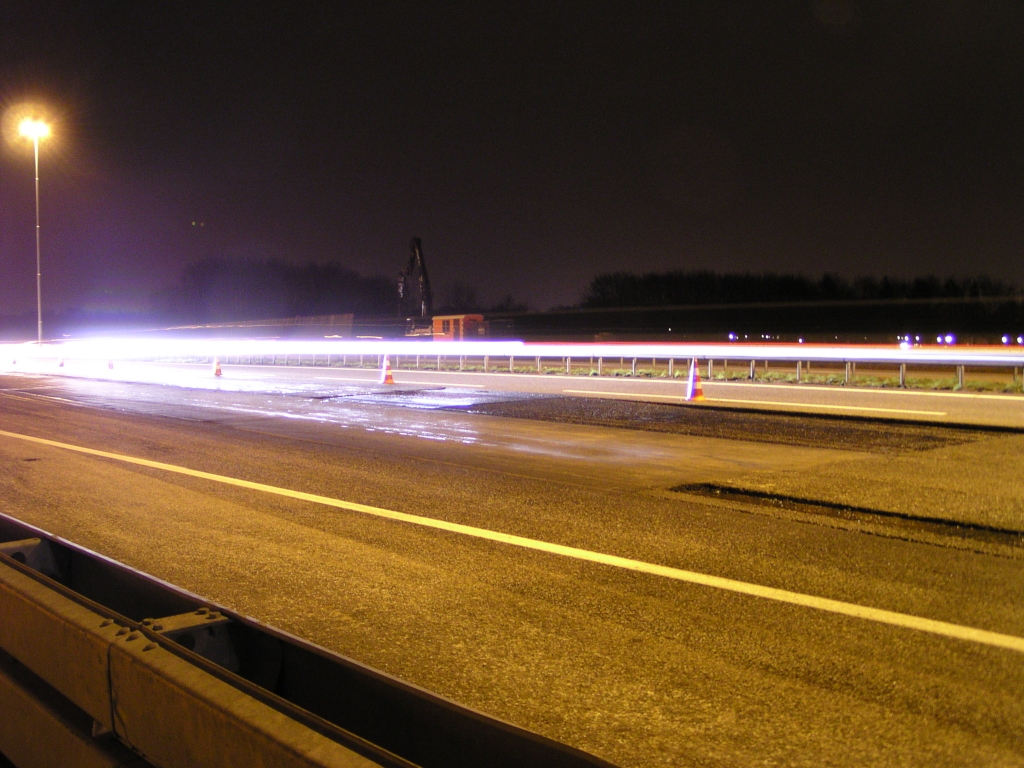 p3150013.jpg - Op de A2 ter plekke is nog maar 1 van de 3 rijstroken beschikbaar voor het verkeer. De asfaltwerken gaan tot rakelings langs de pionnen.