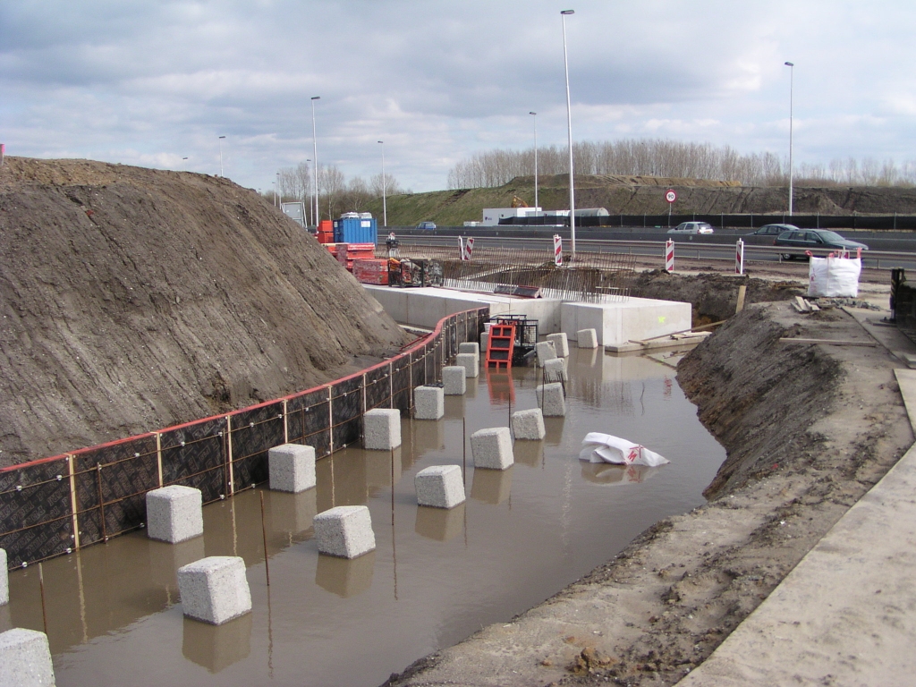 p3230006.jpg - Noordelijke fundering landhoofd voor het viaduct in de aansluiting Ekkersrijt gereed. De verhoogde rotonde zal voor de helft worden "ingepakt" in beton, waarvoor er geheid is en een gedeelte bekisting aangebracht. Een indruk van de vormgeving van de aansluiting geeft  dit animatiefilmpje .