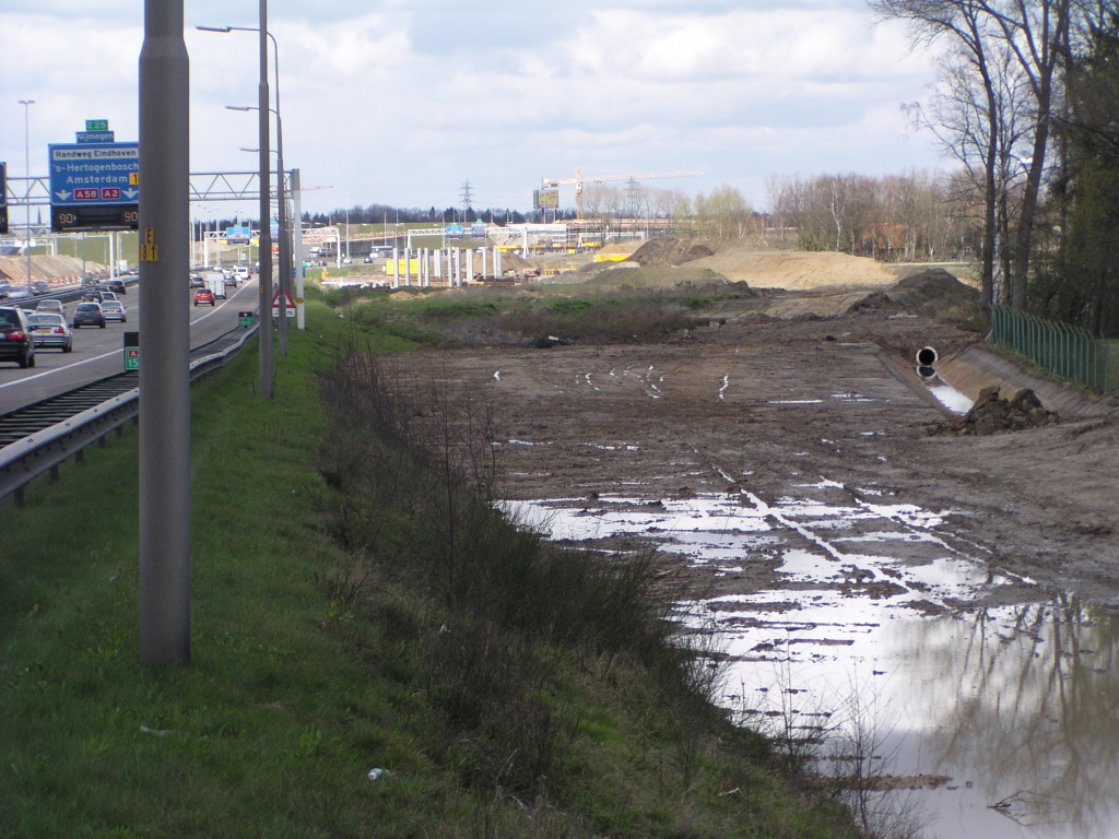 p4060051.jpg - Vanaf het viaduct Oirschotsedijk, waar de wegas zodanig verschoven wordt dat er geen ruimtebeslag in oostelijke richting is, tapert de parallelbaan zich weer los in de richting van KW 7.