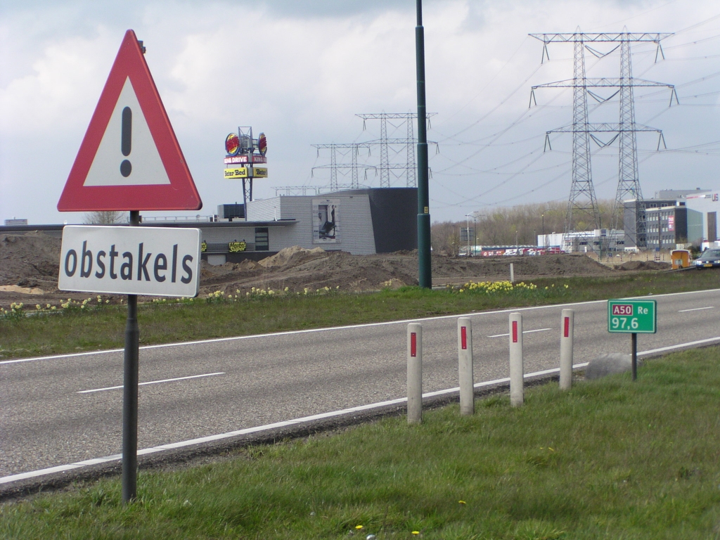 p4130032.jpg - Interessante reeks wegmeubilair langs de A50 tussen de twee VRI's in Ekkersrijt. De obstakels zijn niet de vier reflectorpaaltjes maar een reeks keien die moeten verhinderen dat men, om wat voor reden dan ook, over de berm gaat rijden.