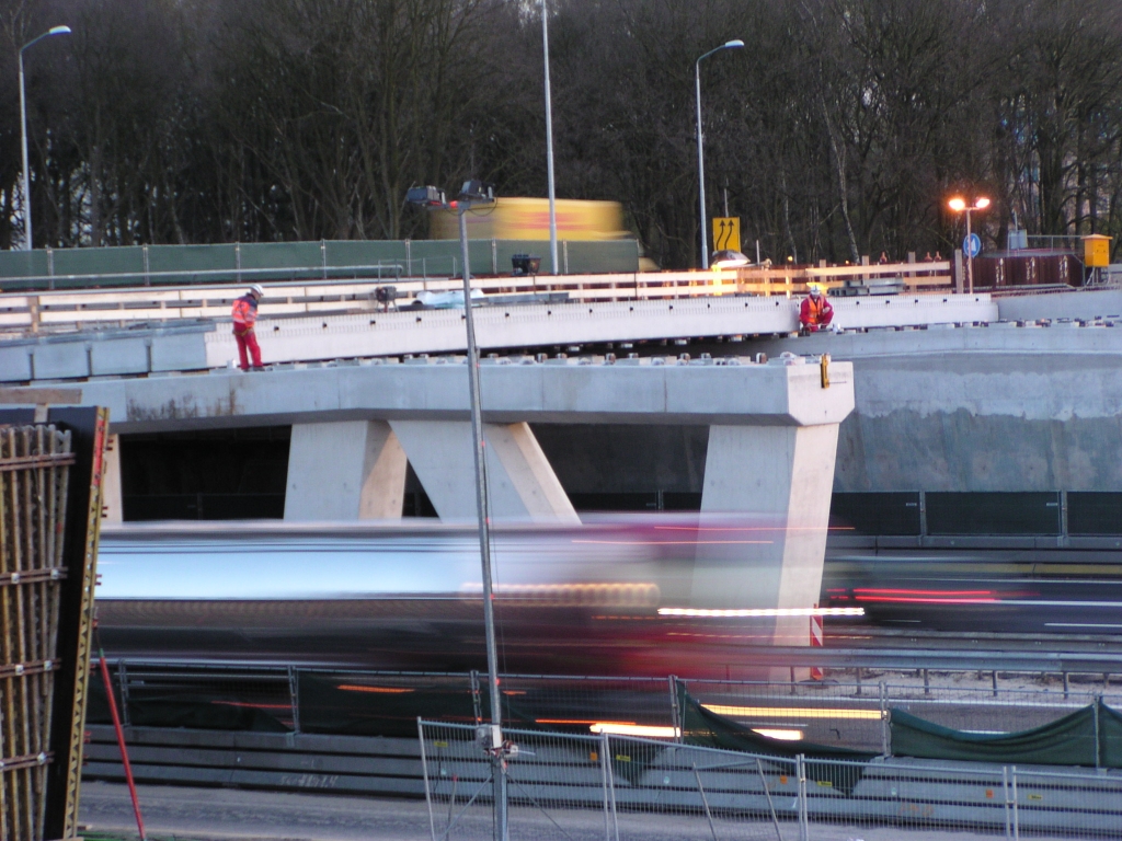 p4150014.jpg - Ook bij het insmeren van de opleggingen met stelmortel raast het verkeer gewoon verder.