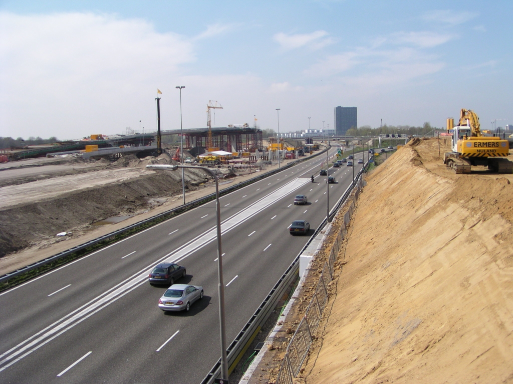 p4200019.jpg - Zandlichamen voor de taluds van en naar de Dommeloverspanningen goeddeels gereed. De ruimte waar nu de bestaande rijbanen liggen is voornamelijk nodig voor de A67 naar Antwerpen en de verbindingsweg van de parallelbaan noord naar de A67, die aftakt van het zandlichaam rechts. Het is hoger dan de andere, omdat even na de Dommel de A67 op ongeveer niveau 2 over de buigende A2 hoofdrijbanen heen gaat.