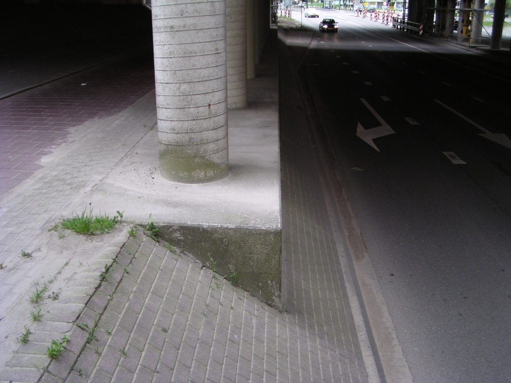 p4300038.jpg - Een ander punt dat onderwerp zou kunnen zijn van historisch onderzoek naar de randweg Eindhoven. Waarom ligt de Noord-Brabantlaan hier verdiept onder de A2, evenals de onderdoorgang Meerenakkerweg, maar ligt de "Poot van Metz" wel hoog genoeg bij de aansluiting Veldhoven-zuid en de onderdoorgangen Ulenpas en Cranendonck? Was het zand op in 1968? Een gevolg van de het te lage dijklichaam hier bij KW 13 is dat voor het vervangen van het fietspad door een opstelstrook voor het verkeer richting Maastricht hier een damwand moet worden ingedrukt om ruimte te maken.