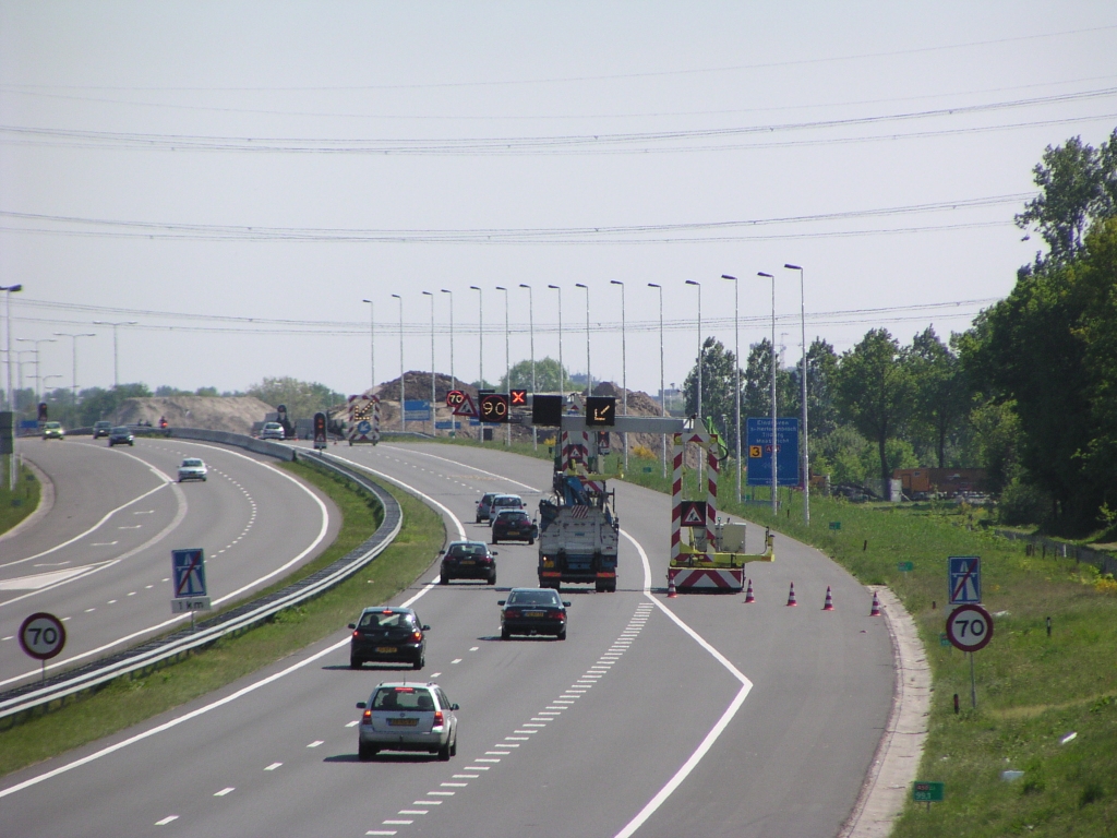 p5100002.jpg - Ook weer fraaie ruimtereserveringen op en nabij de Wilhelminabrug in de A50, die nu mooi van pas komen voor 4+0 faseringen. Thans wordt de rechter rijbaan voorbereid op zo'n fasering, en is er maar 1 rijstrook beschikbaar. De bedoeling is de linker rijbaan verkeersvrij te krijgen om ruimte te maken voor met name nieuwe kunstwerken over Ekkersrijt 2000. De middengeleider is op het doorsteekpunt reeds vervangen door een barrier.