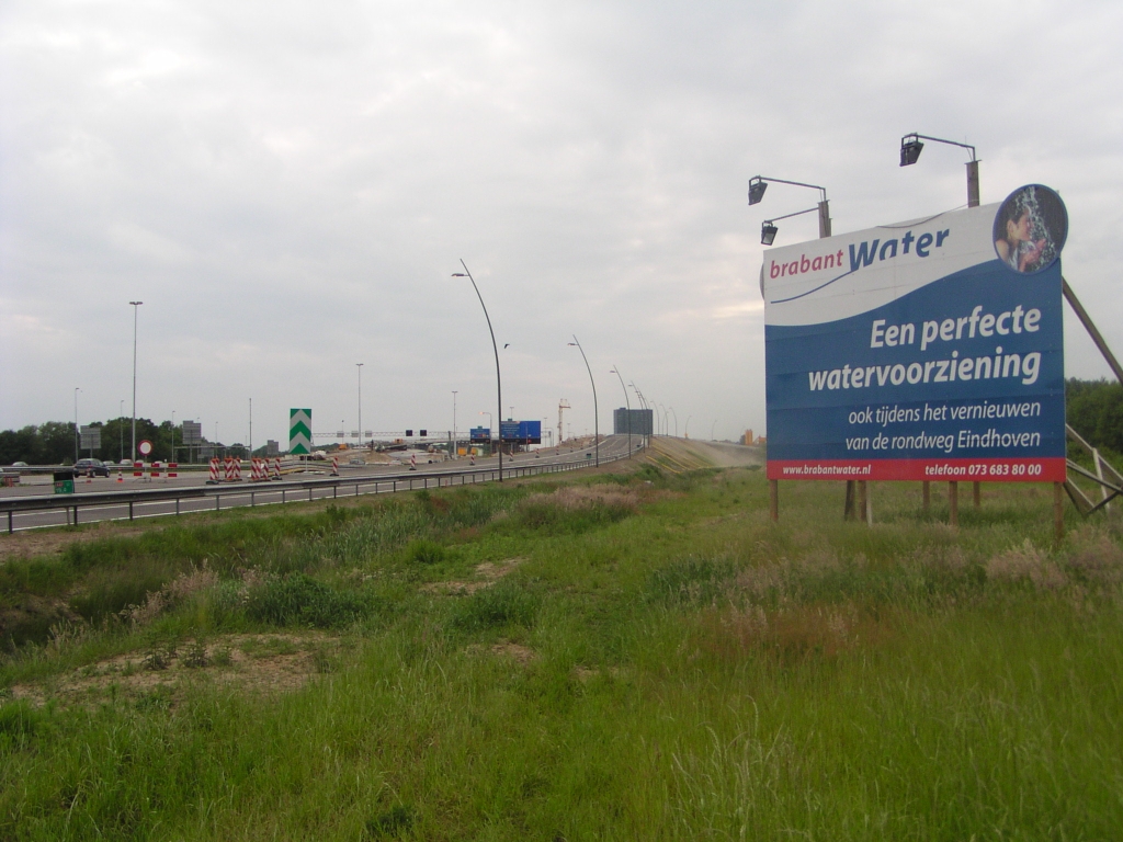 p5240045.jpg - Dit lijkt misschien een holle reclameleus, maar er is/wordt veel werk verzet om (hoofd-)waterleidingen te verleggen tijdens de randweg (en niet rondweg zoals op het bord staat) verbouwing.