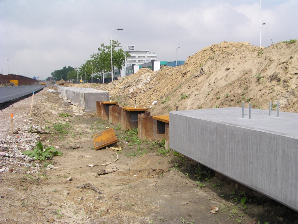 p5250018.jpg - Aan de draadeinden te zien komt er toch een (transparant?) geluidsscherm langs dit trace, wat we niet vaak zien bij een bedrijventerrein. De fundering ervoor loopt hier over van een betonnen sierrand op damwanden naar een betonstrip op maaiveld.