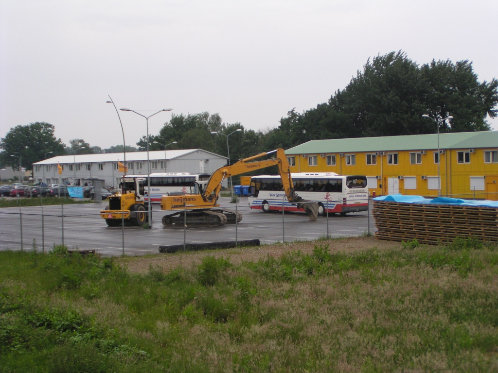 p5310011.jpg - Het verlaten parkeerterrein voor de gele Heijmans keet werd benut als opstapplaats voor een aantal touringcars voor een rondrit over de Randweg Eindhoven. Om het publiek alvast in de stemming te brengen zijn een aantal grondbewerkingswerktuigen tentoongesteld.