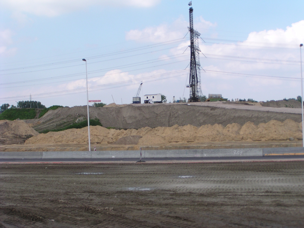 p6010055.jpg - Zandlichaam in de A50 ontdaan van de "oren" die aangaven dat ter plekke de verbindingsweg Eindhoven Woensel in de richting Tilburg daar weer op niveau 2 overheen zou gaan. In de plaats daarvan nu een hei-installatie.  week 200816 