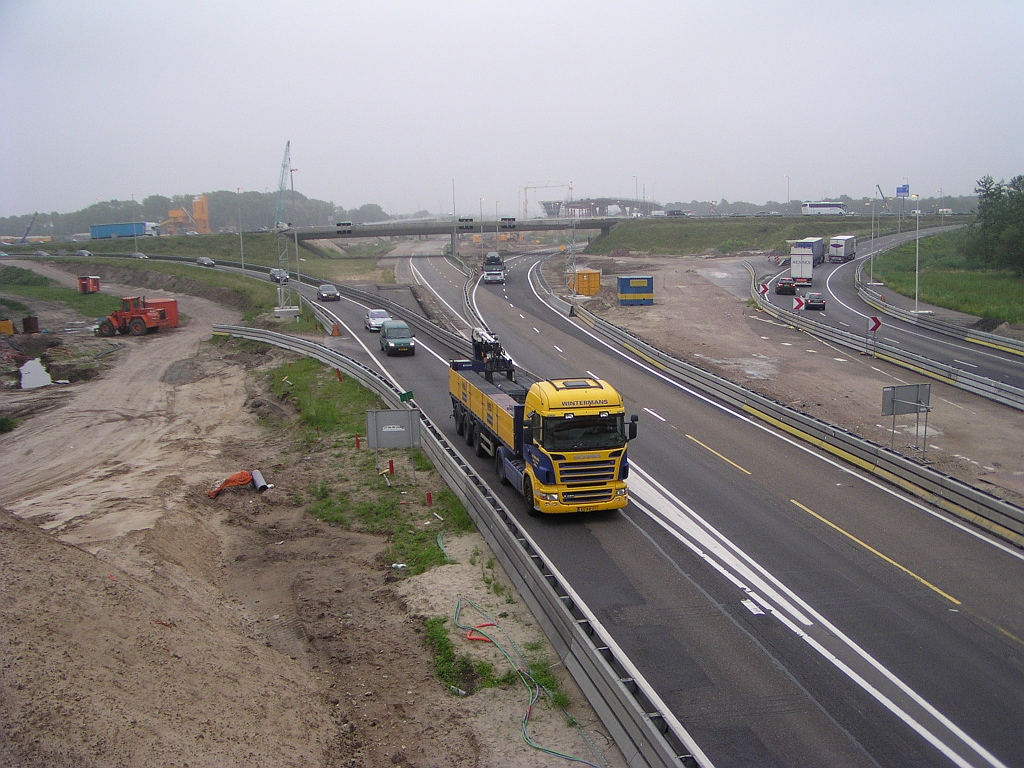 p6050048.jpg - Zelfde punt op dag van openstelling. In de uiteindelijk situatie komt dit A67 trace weer op zijn oude plek te liggen, maar is dan nog aan het dalen van de ongeveer op niveau 2 liggende overspanning over de A2 hoofdrijbanen. Het viaduct op de foto moet dan dus al gesloopt zijn, althans de linker moot, als dat apart van de rechter moot mogelijk is.