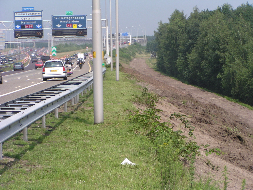 p6080036.jpg - Schoongeschraapt talud aan de zuidzijde van het weefvakkengebied tussen KW 3 en kp. Ekkersweijer. De tracekaart wekt de suggestie dat er hier een ruimtereserving wordt gerealiseerd voor een extra rijstrook, misschien ten behoeve van een 2x3 A2 tussen Eindhoven en 's Hertogenbosch.