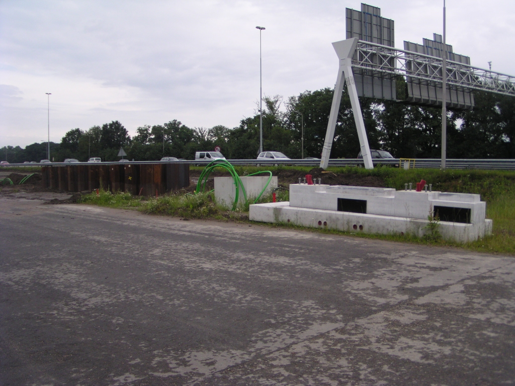 p6140144.jpg - Nog meer te beleven op de parallelbaan nabij KW 8. Van links naar rechts een damwanden constructie, de "schoorsteen" van een amfibietunnel, en een A-portaal fundering. De amfibietunnel laten we even voor wat hij is. De portaalfundering zou zo maar eens kunnen passen in die damwanden omhulling. Steilere taluds in de parallelbanen maken zulke uitstulpingen in de nieuwe hoofdrijbaan noodzakelijk, aannemende dat de hellingen even flauw blijven als in de bestaande hoofdrijbaan in de foto.