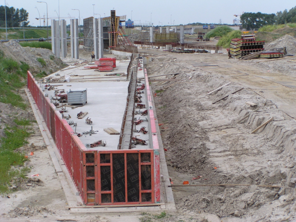 p6290056.jpg - Andere weeftunneltjes gezien hebbende, verwachten we op dit uitsteeksel een schuin oplopende muur naar het tunneltje toe. Maar dit exemplaar staat niet in lijn met de rest van het kunstwerk. Uit de tracekaart blijkt dat het weefcomplex aan de oostzijde compacter is in de breedte dan aan de westzijde. Misschien dat dat de reden is voor de knik in het kunstwerk.