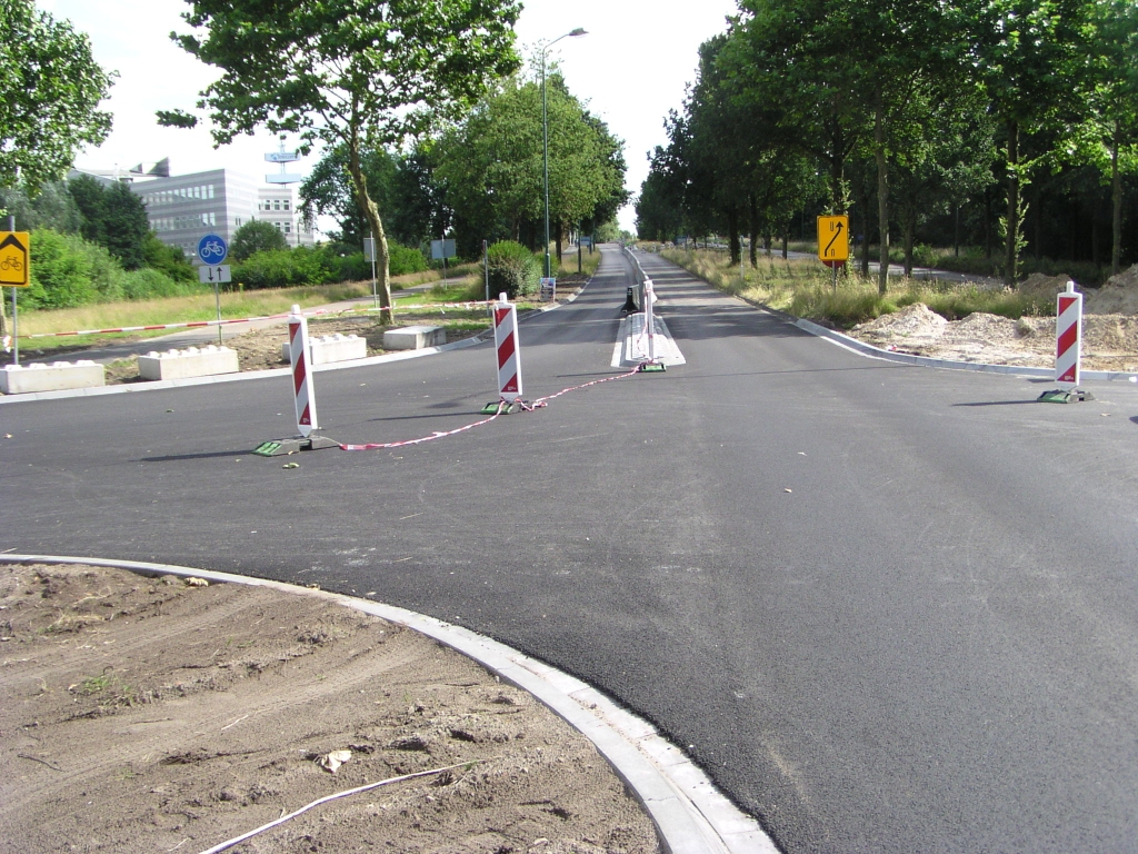 p7060051.jpg - Op het onderliggend wegennet in het bedrijventerrein Ekkersrijt zijn enkele wijzigingen in aanleg, die wellicht verband houden met de nieuwe aansluiting. We kijken hier richting Eindhoven, waar de Huizingalaan met 2x2 over de A58 gaat. De oostelijke rijbaan is over een aantal meters voorzien van een rijstrookscheiding.