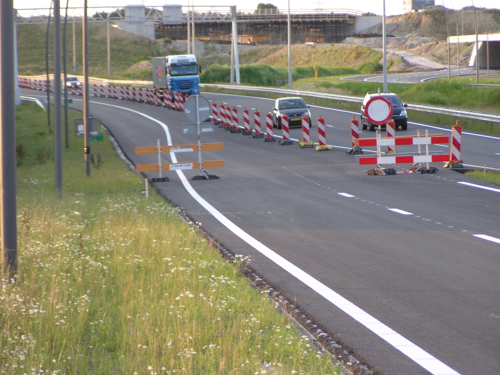 p7140047.jpg - Onmiskenbare overgang tussen autosnelweg en parallelbaan: het verdwijnen van de vluchtstrook.