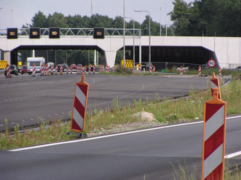 p8100074.jpg - KW 9 is op zich ver genoeg voltooid dat de parallelbaan er onder zou kunnen lopen. OWN moet echter nog worden verbouwd zodat de sloop van het in de weg liggende oude viaduct pas eind september voorzien is. Vandaar dat het aanstonds te openen parallelbaanwegvak vlak voor KW 9 weer terugbuigt naar de oude hoofdrijbaan. Direct achter KW 9 is de parallelbaan al langer gereed. We krijgen hier dus een dubbele slinger.