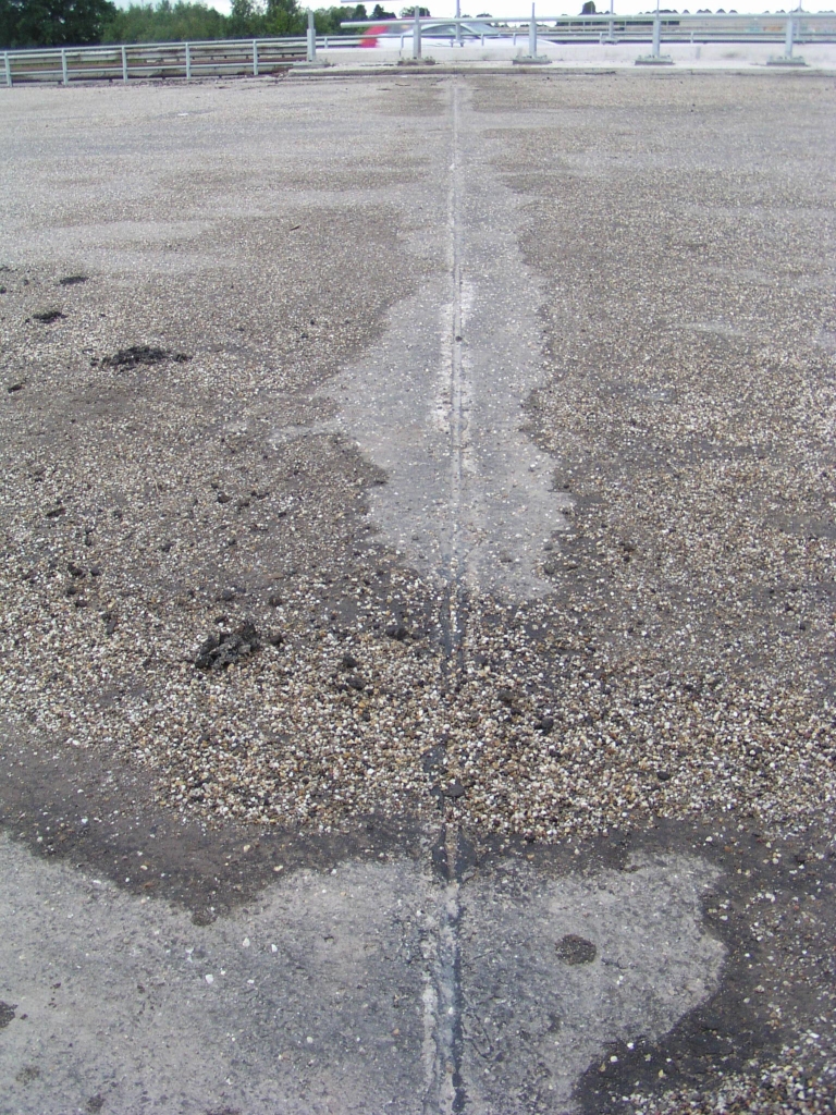 p9070043.jpg - KW 15 heeft een relatief korte overspanning en kon daarom worden uitgevoerd als een integraalviaduct, zonder opleggingen en voegovergangen dus. Toch is er een soort insnijding in het asfalt met (bitumen?) opvulsel.