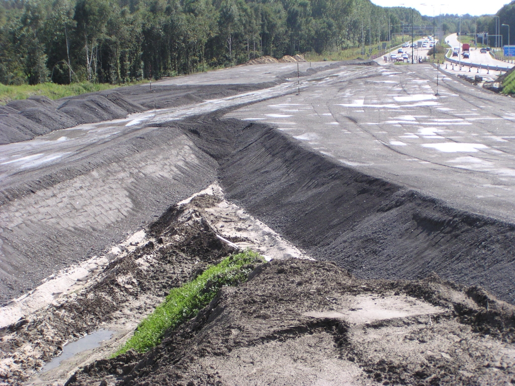 p9140025.jpg - Keuzepunt vanuit Woensel uit de richtingen A50 Oss (links) en Tilburg (rechts). Rechts zou het in een relatief korte afstand moeten stijgen tot niveau 2, terwijl links maar naar niveau 1 hoeft. Op het splitsingspunt zal het daarom wel hoger komen te liggen dan niveau 1 en zou dus het linker dijklichaam weer wat gaan  dalen .