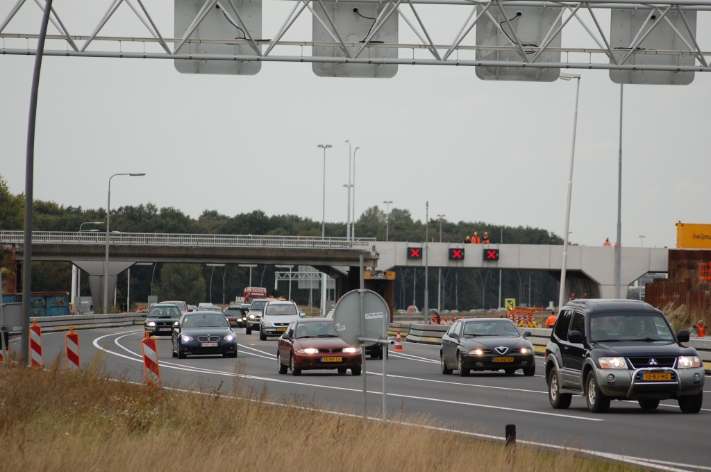 20081004-172657.jpg - Verkeer onder de oude moot is nog niet omgeleid, maar zal straks enkelstrooks over de andere rijbaan geleid worden. Het verkeer op die andere rijbaan staat op het moment te wachten achter een politiestop voor het instellen van een omleiding over de af- en toerit, rechts buiten beeld.