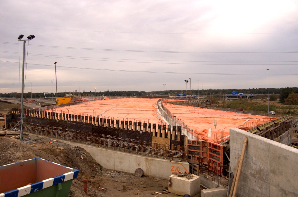 20081102-161636.jpg - Ook bovenop het kunstwerk loopt de weg enigzins gebogen. De oranje folie verraadt recent stortwerk. Het was met 2700 kubieke meter de grootste betonstort operatie tot nog toe in het project. Zie verder het  Eindhovens Dagblad .