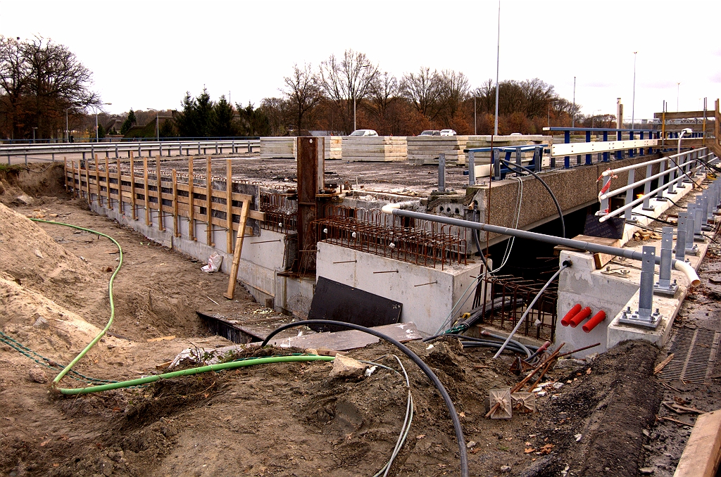 20081116-153608.jpg - Aan de onderbreking in het nieuwe beton, waar de roestige stabilisator in staat, is goed te zien hoeveel het landhoofd aan hoogte gewonnen heeft. Dat gat moet na verwijdering van de stabilisator uiteraard ook nog worden opgevuld. Dan kan het verder met nog maar een plak beton voor de voegovergangen, en nieuwe stootplaten. Verheugend om te zien dat al een gedeelte van de oude brugleuning is verwijderd.