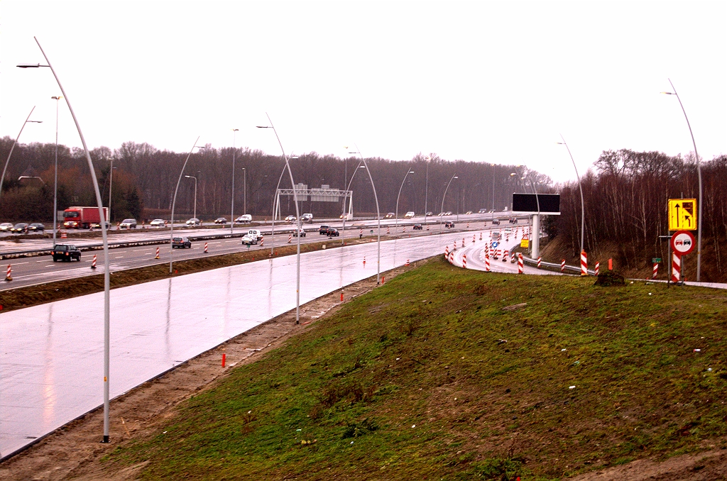 20081220-140259.jpg - Toplaag-gereed asfalt op de parallelbaan oost ten noorden van KW 9 (aansluiting Airport) met afwateringsputten aangebracht. Ook lichtgrijze lichtmasten geplaatst die een autosnelwegprofiel beloven. Die masten staan ook op de toerit in de richting Amsterdam, zodat dat we hier de enigste toerit in de Randweg Eindhoven gaan krijgen die direct autosnelwegstatus heeft.  week 200845 