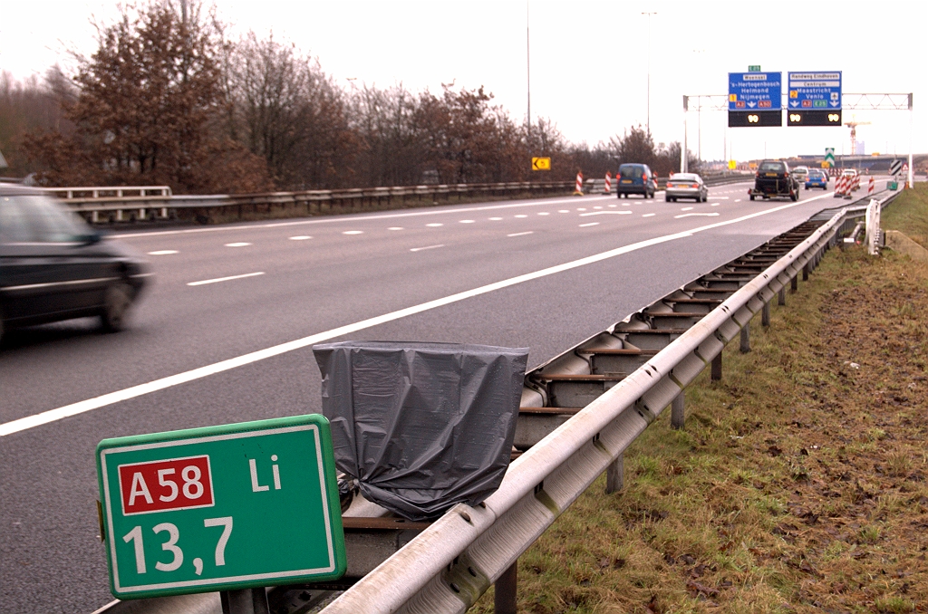 20081221-110038.jpg - Nieuwe hectometerbordjes langs de zuidelijke A58 rijbaan vanaf de brug over het Beatrixkanaal, het knooppunt Batadorp in. Maar waarom? Geen reden te verzinnen om wegnummer of kilometrering te wijzigen op dit punt. Het zou een routinevervanging kunnen zijn, maar waarom dan de tijdelijke afdekking met vuilniszakken? Gewoon het oude bordje verwijderen en de nieuwe in gebruik nemen.