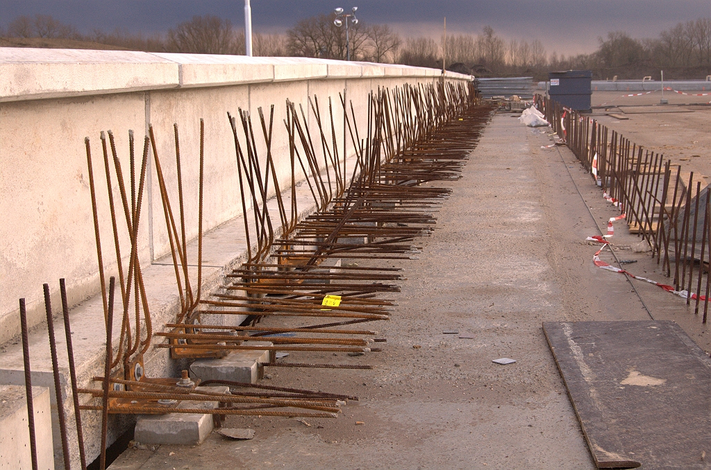 20090118-160905.jpg - De zijprofielen zijn vooralsnog alleen met stalen hoekjes, bouten en moeren bevestigd aan het kunstwerk. De definitieve verankering vindt plaats in de nog aan te leggen betonnen stoep waar de wapening van de prefab elementen in verwerkt wordt.