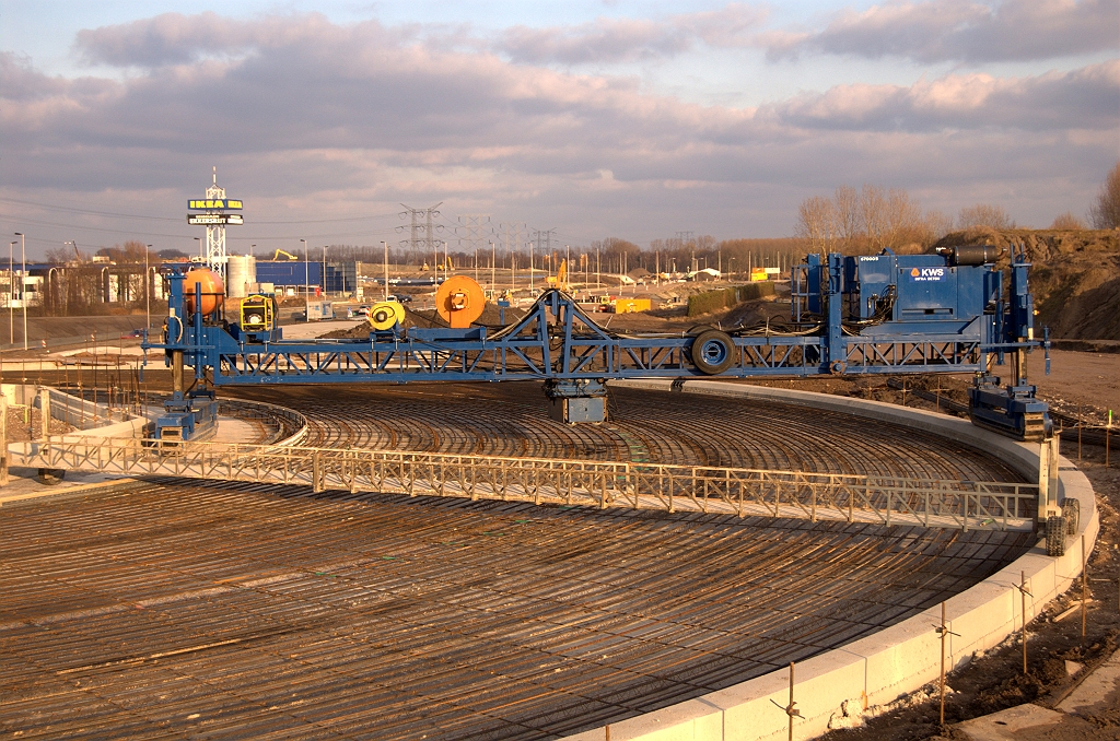 20090214-163424.jpg - Er is hulp ingeroepen van de firma KWS. Het lijkt een egaliseerapparaat teneinde het te storten beton vlak te strijken tot een mooi gladde rijbaan.