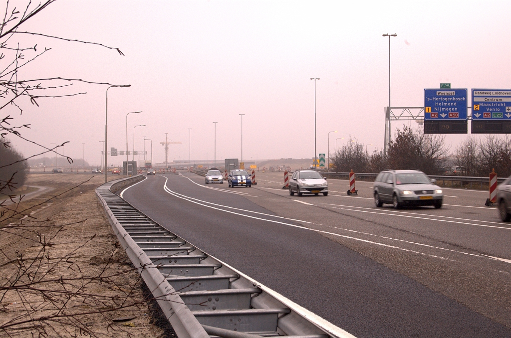 20090221-111017.jpg - De (tijdelijke?) verbreding van de noordelijke A58 rijbaan tussen kp. Batadorp en de brug over het Beatrixkanaal is in gebruik genomen. Verkeer is verplaatst zodat er werkruimte tussen de rijbanen is ontstaan. Al snel is slijtage van de doorgetrokken strepen opgetreden, wellicht door bestuurders vanuit de richting Nijmegen die vrezen de afrit Best te zullen missen.