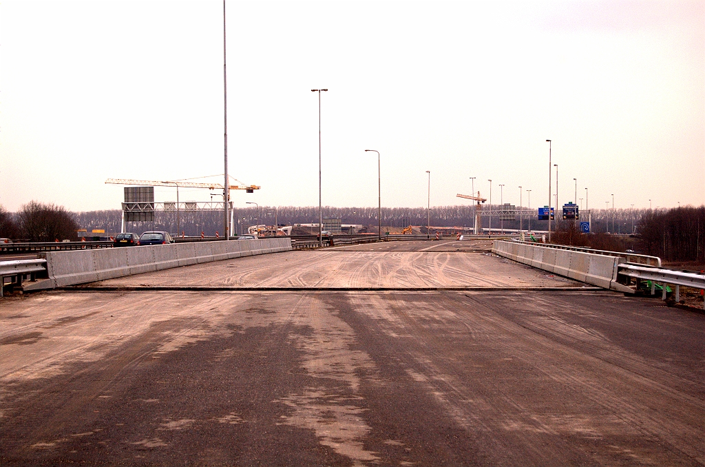 20090221-161219.jpg - Stalen barriers teruggeplaatst in KW 3-noord. In 1974, toen het viaduct werd opgeleverd, gingen er nog twee A58 rijstroken met vluchtstrook overheen en begon de uitvoeger voor de A2 richting Maastricht pas na het viaduct. Later heeft men de vluchtstrook opgegeven om een doorgaande strook voor de A2 te kunnen realiseren tussen kp. Ekkersweijer en kp. Batadorp. Als we het vorige bord mogen geloven gaan er nu dus vier rijstroken tussen de barriers geperst worden.