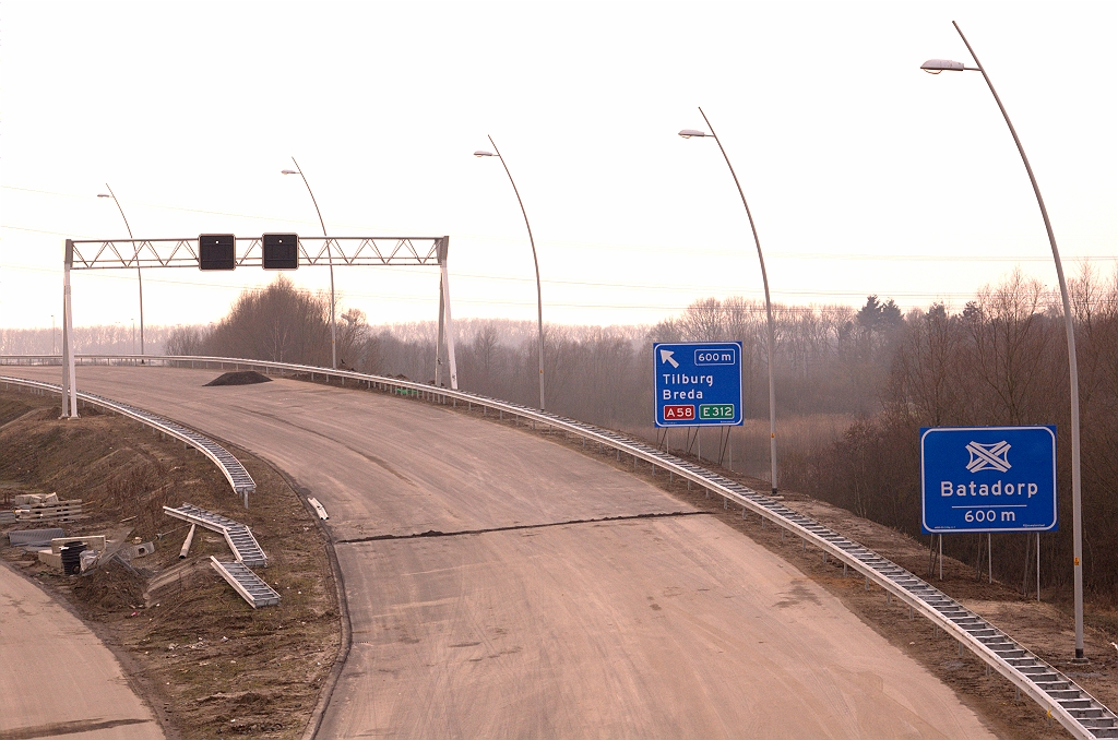 20090228-163903.jpg - Eerste knooppuntbord in de stijl van de Vernieuwing Bewegwijzering (VNB). Het is in de vlechtwerken tussen de knooppunten Ekkersweijer en Batadorp vooralsnog alleen te vinden langs de A50/A58. Jammer dat het direct gevolgd wordt door een tijdelijk bord in ouderwetse uitvoering.  week 200908 