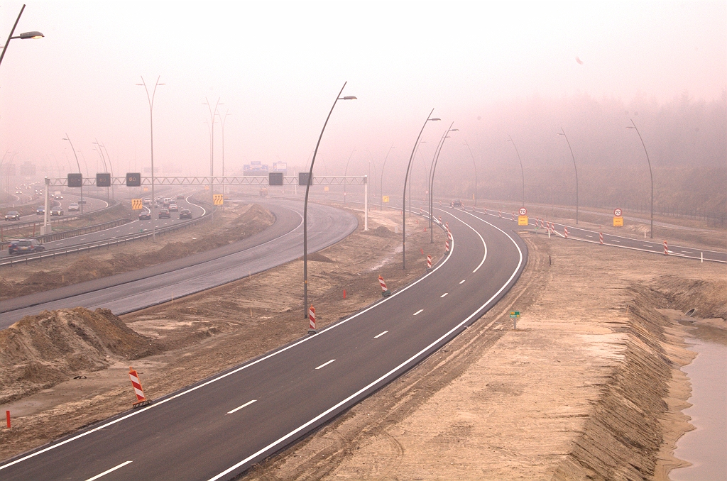 20090307-094624.jpg - Het verkeer vanaf de aansluiting Veldhoven moet eerst invoegen op de toerit Centrum, en vervolgens op de parallelbaan in de richting Airport, maar dat is in de mist niet meer te zien. Wel te zien: vers asfalt op de oostelijke hoofdrijbaan.  week 200908 