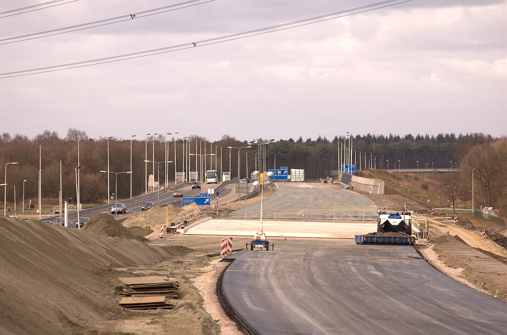 20090315-151239.jpg - De reden daarvoor is duidelijk: asfalt aangebracht tussen KW 41 (viaduct over Ekkersrijt 2000/6000) en de brug over het Wilhelminakanaal. Ook nieuw asfalt in de verbindingsweg Woensel-Nijmegen, maar daar gaan we dadelijk verder naar kijken. Links van dat asfalt is ook de oostelijke A50 rijbaan aangelegd in de richting van KW 41, maar goeddeels aan het oog onttrokken door een faseringszandlichaam.